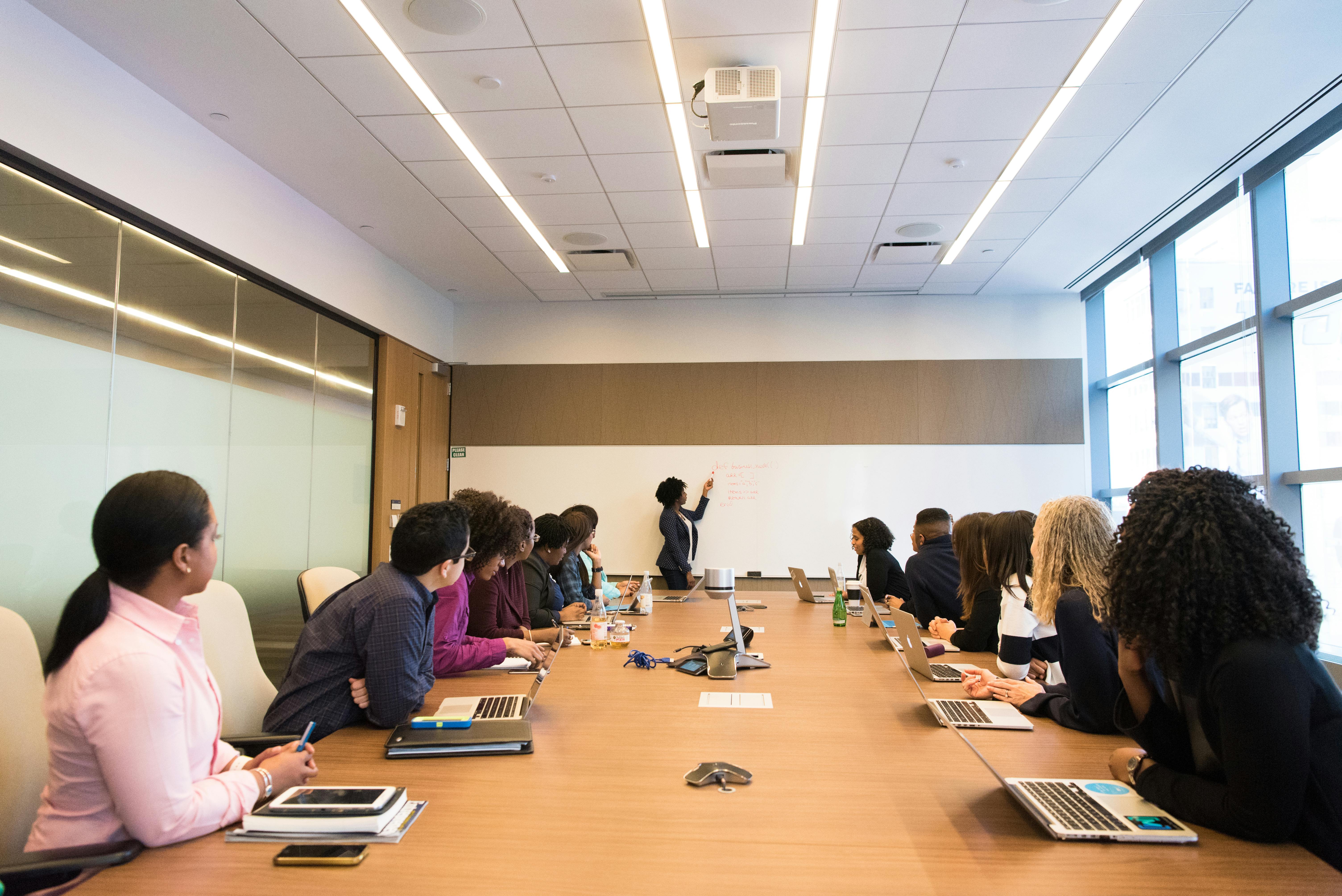 Diverse professionals engaged in an executive coaching session in a modern conference room